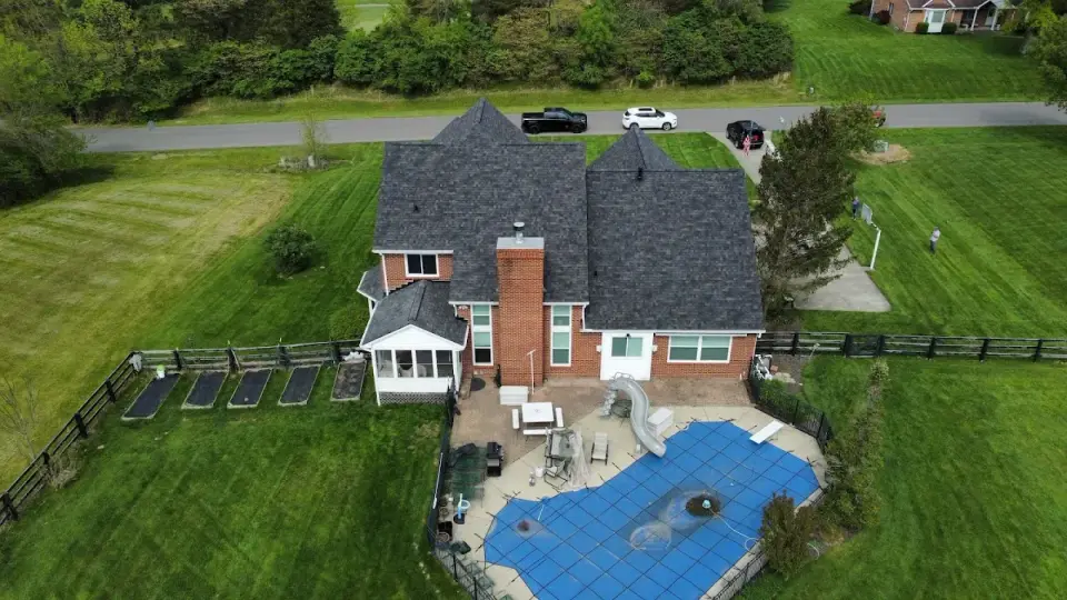 Aerial view of a brick home with a new roof and backyard pool in Blue Ash, Ohio