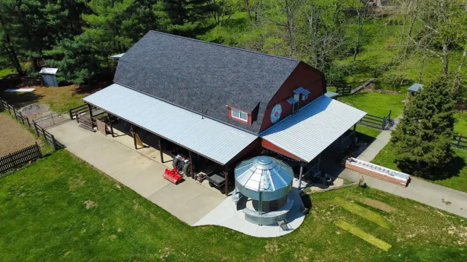 New shingle roof on a barn with metal porch roofs and a grain bin in Loveland, Ohio
