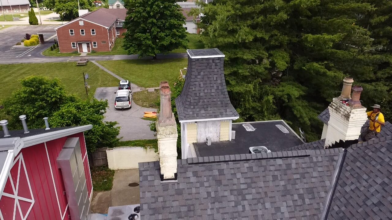 Aerial view of a completed shingle roof with chimney work in Mason, OH