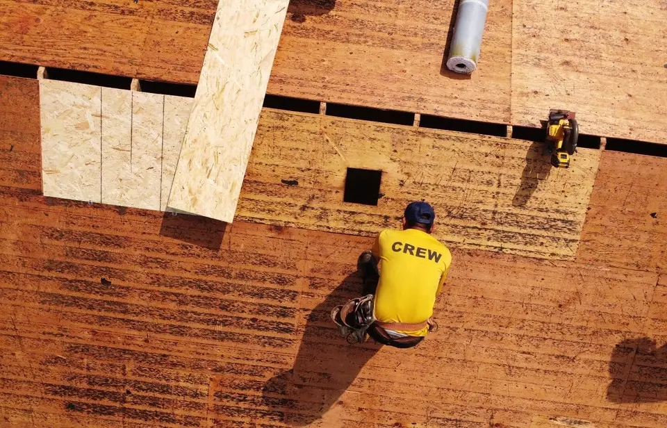 Aerial view of a crew member working on new and existing roof decking in Montgomery, Ohio