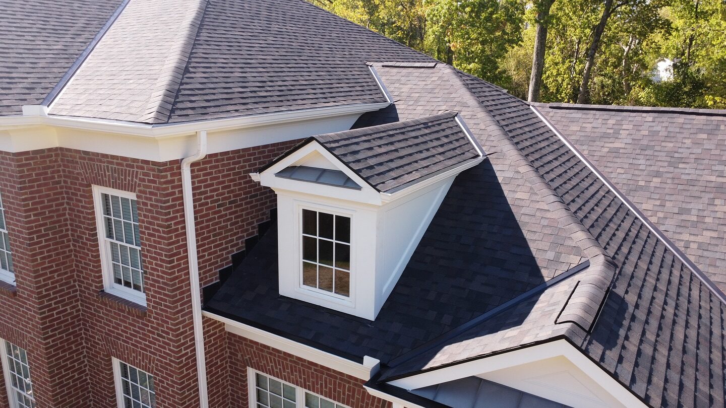 Close-up of dormer flashing and architectural shingle detail on a brick home in West Chester, OH