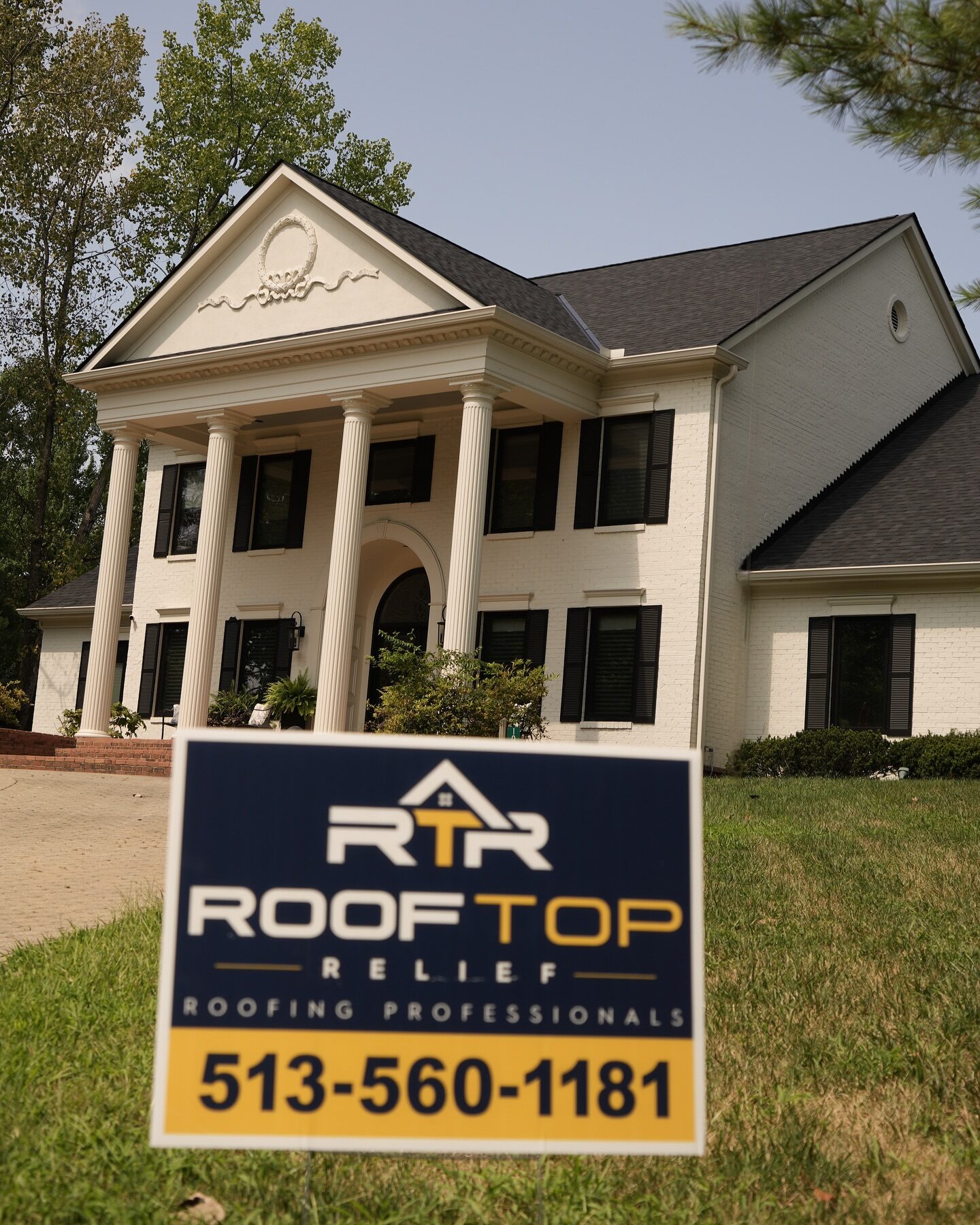 Completed roof replacement on a colonial home in West Chester Township with Rooftop Relief yard sign